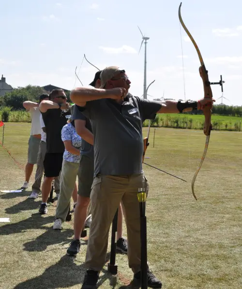 A group of novice archers firing bows